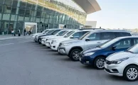 Línea de vehículos modernos de alquiler estacionados en la terminal del Aeropuerto de Carrasco listos para su retiro.