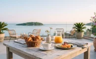 Desayuno servido en una terraza frente al mar con café, medialunas y fruta, uno de los restaurantes para visitar en Punta del Este a primera hora